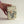 Hand holding a decorative stone box with floral patterns on a plain background